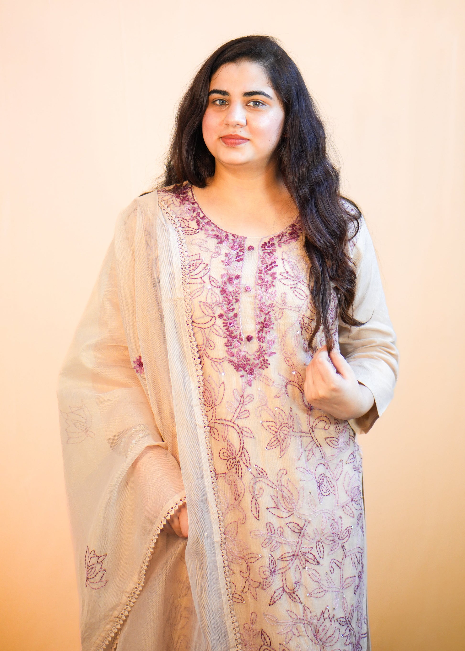 Woman wearing a traditional outfit with floral patterns on a beige background