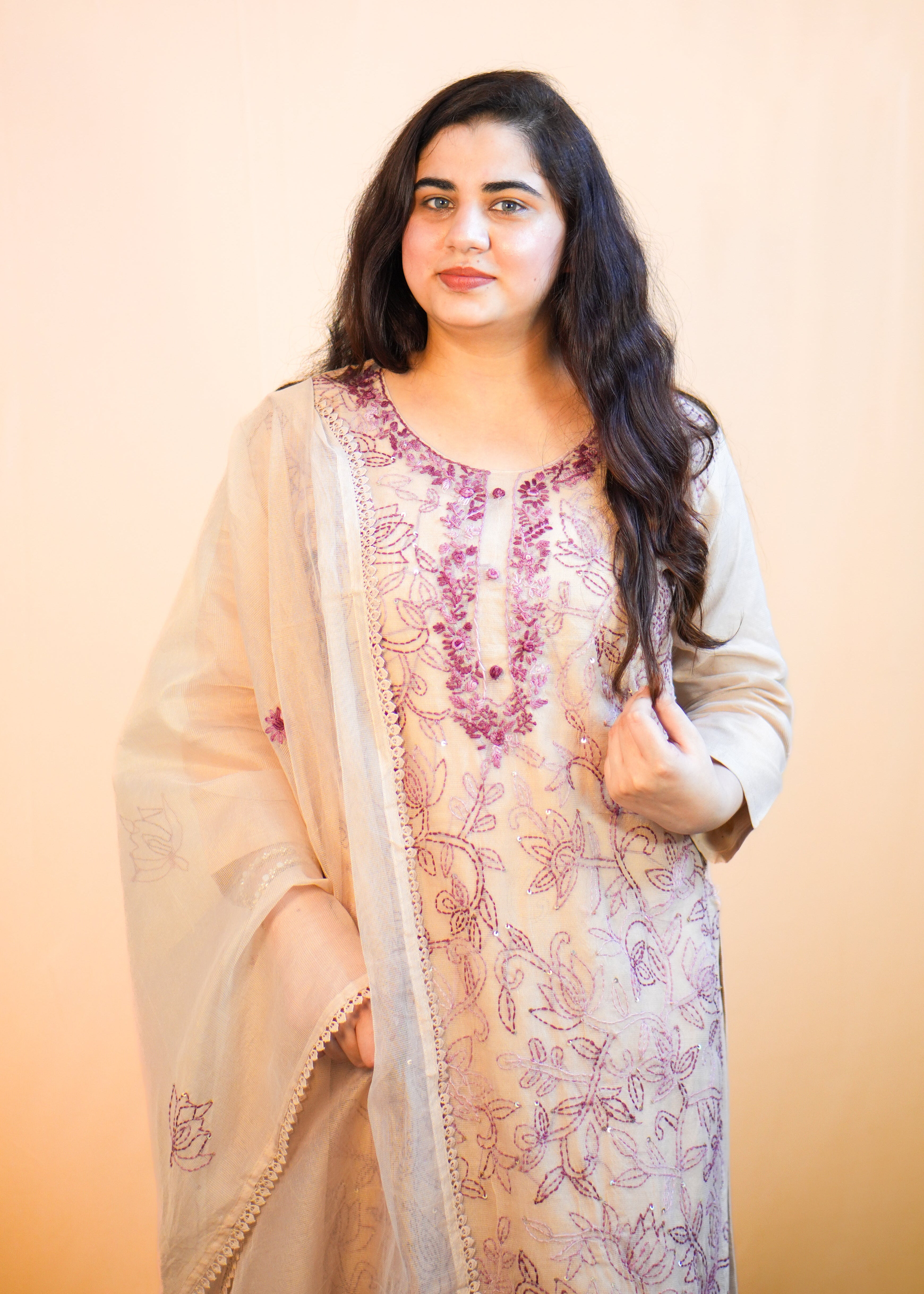 Woman wearing a traditional outfit with floral patterns on a beige background