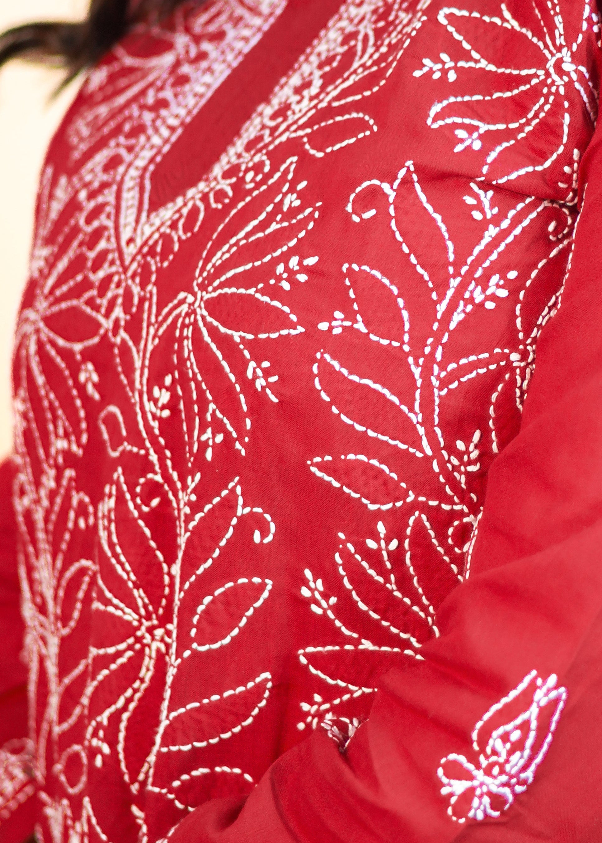 Red traditional outfit with white floral patterns worn by a person.