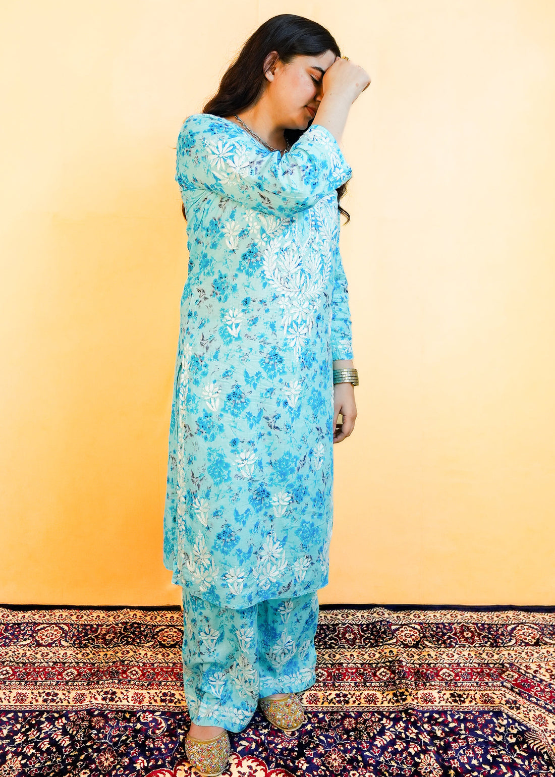 Woman wearing a blue floral dress against a yellow background