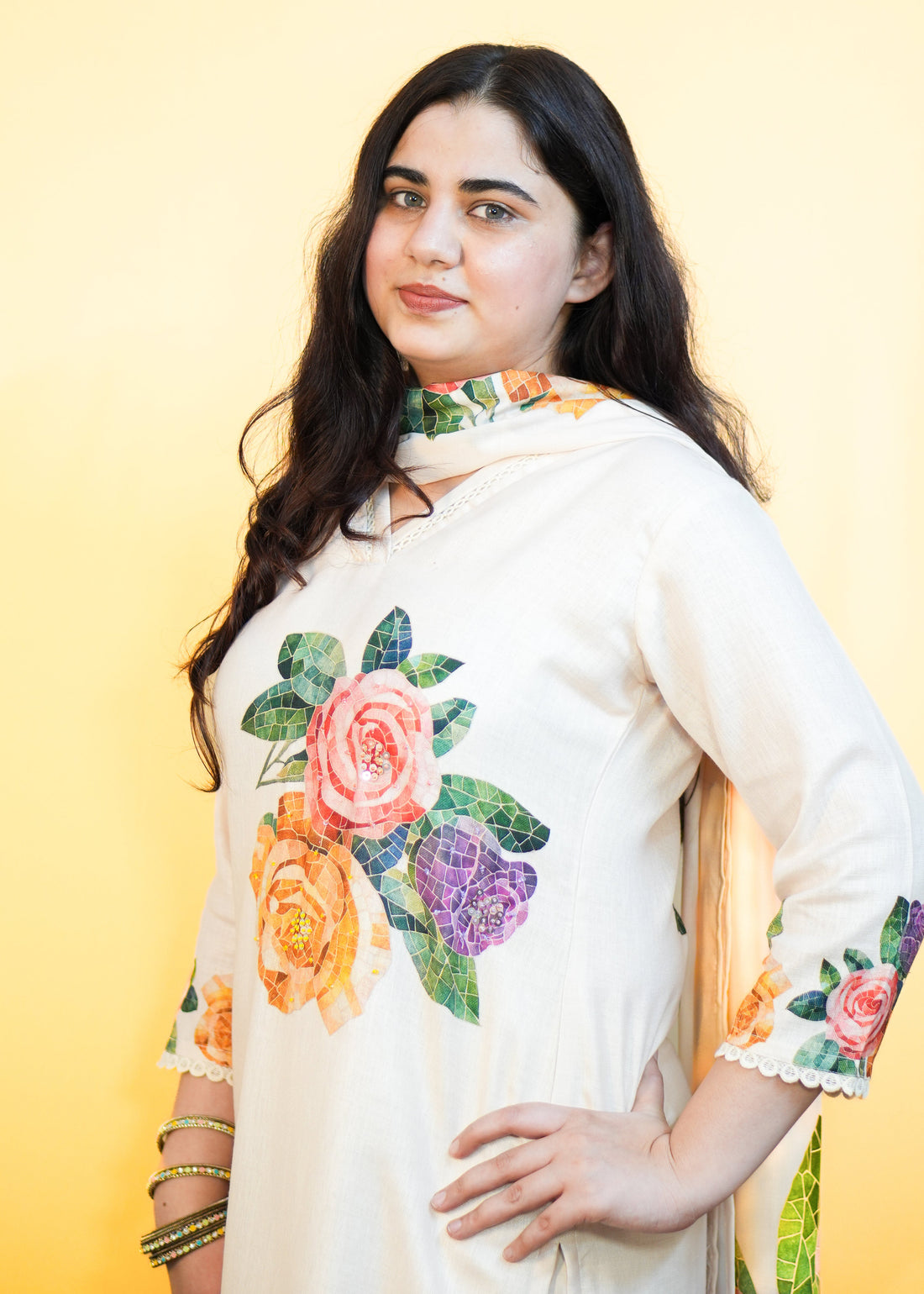 Woman wearing a white outfit with floral patterns on a yellow background