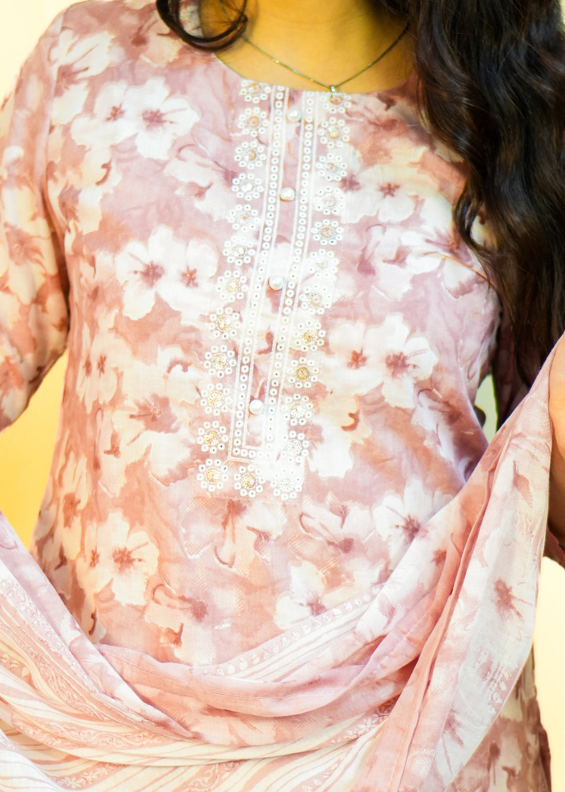 Woman wearing a floral dress against a yellow background
