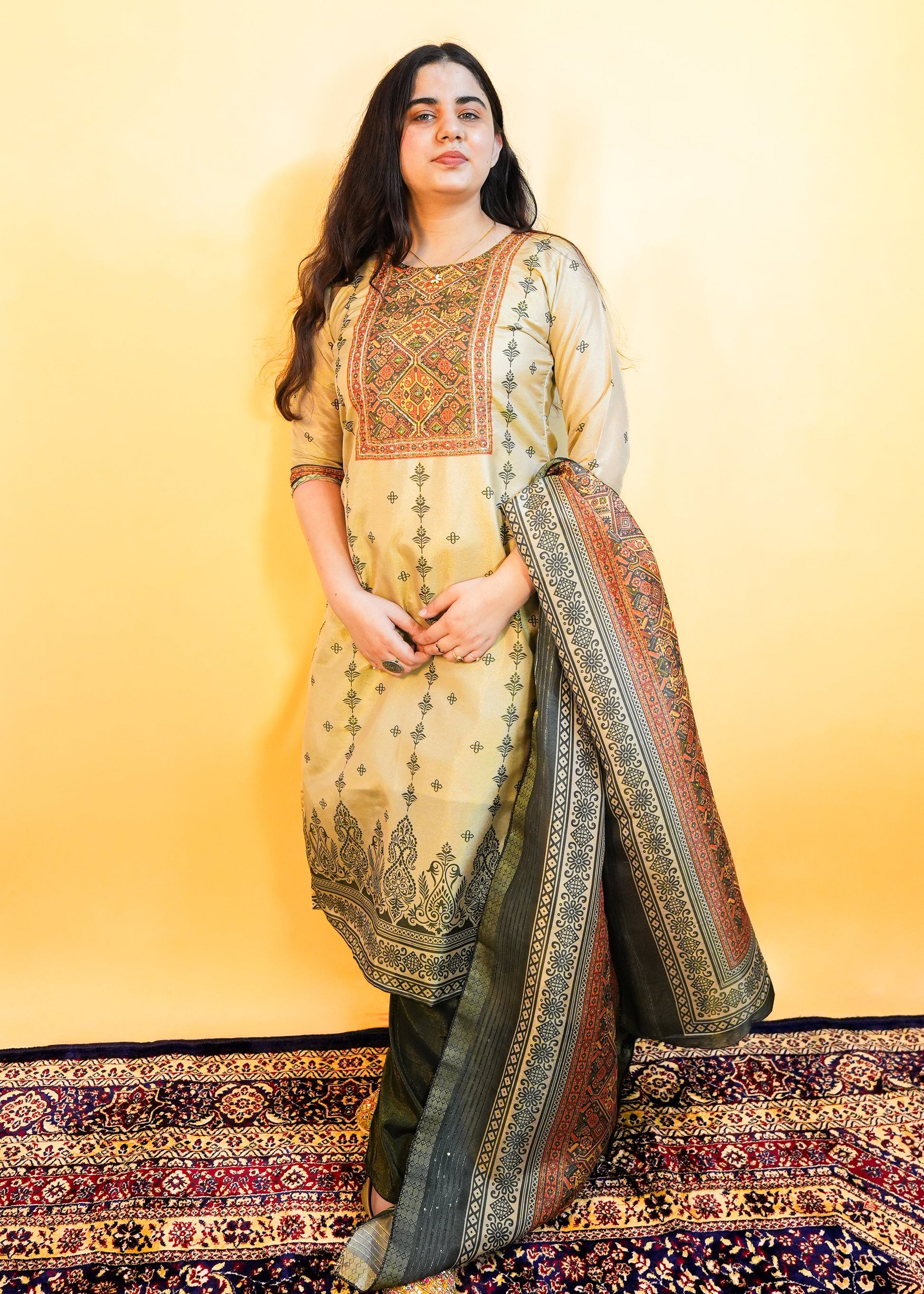Woman wearing a traditional outfit with a patterned dupatta against a yellow background