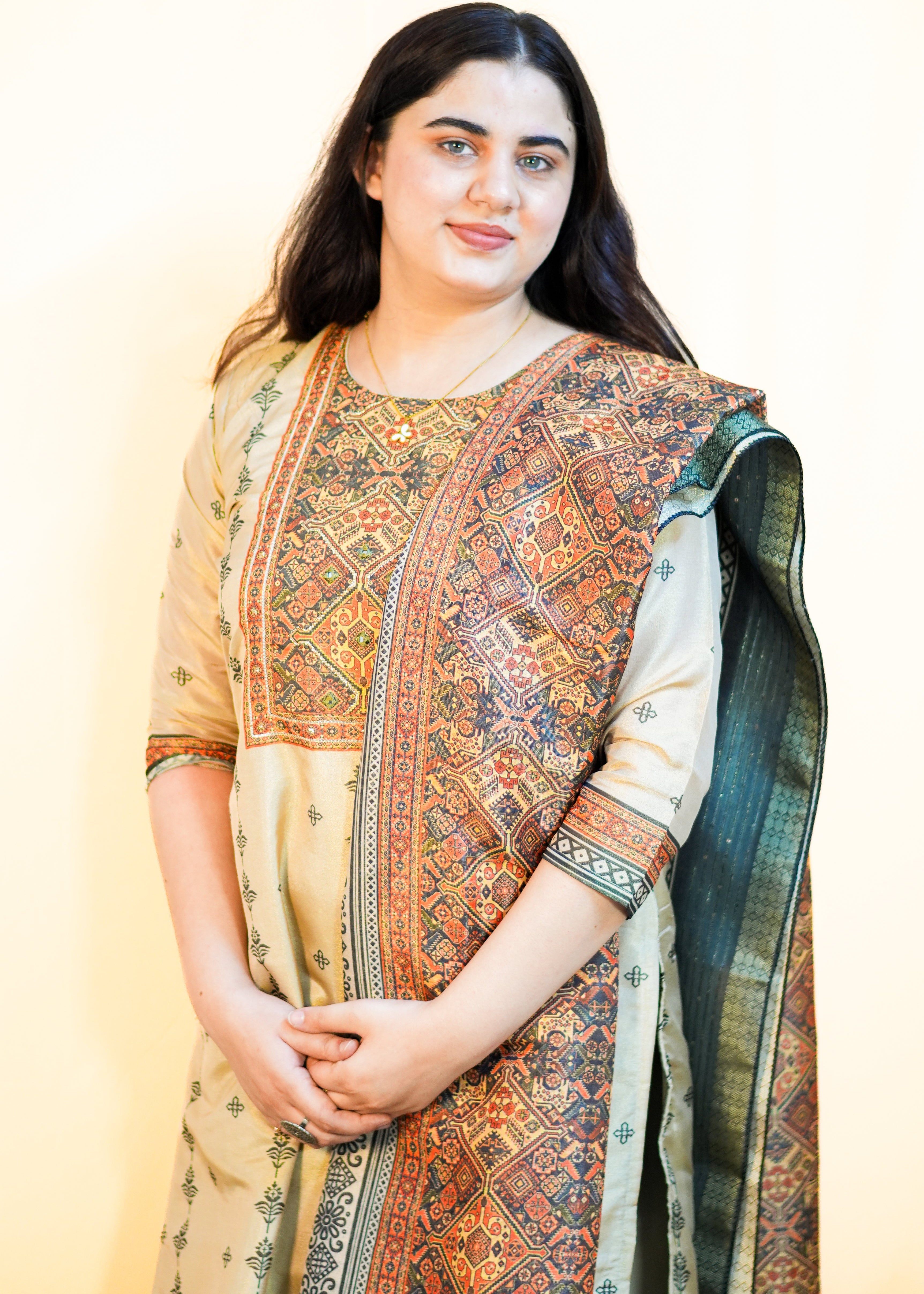 Woman wearing a traditional patterned outfit with a plain background