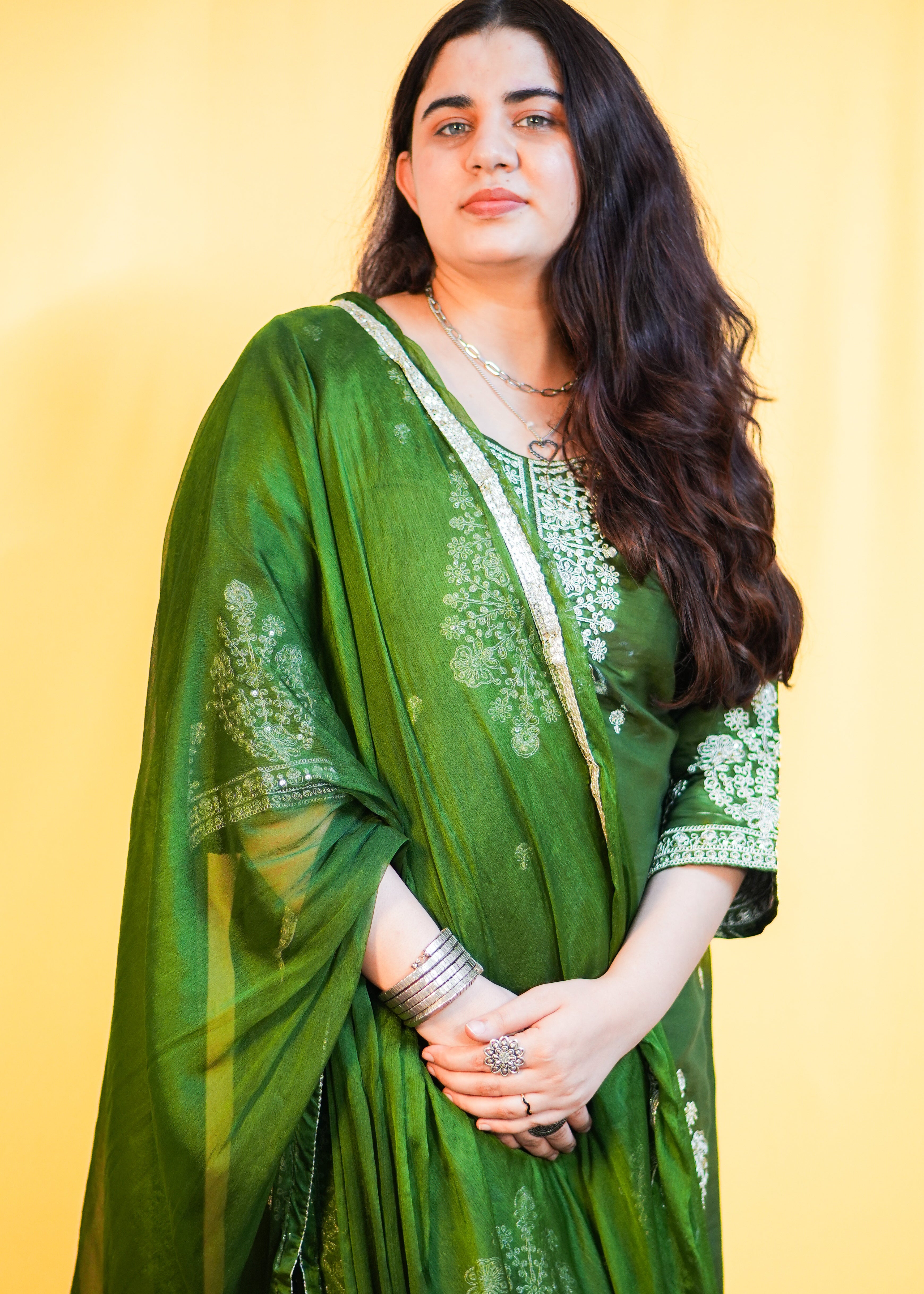 Woman wearing a green suit with a yellow background