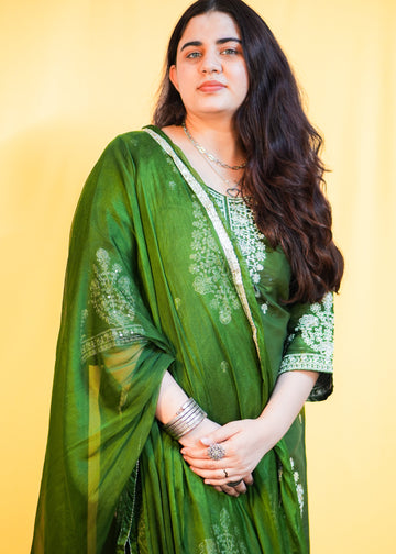 Woman wearing a green suit with a yellow background
