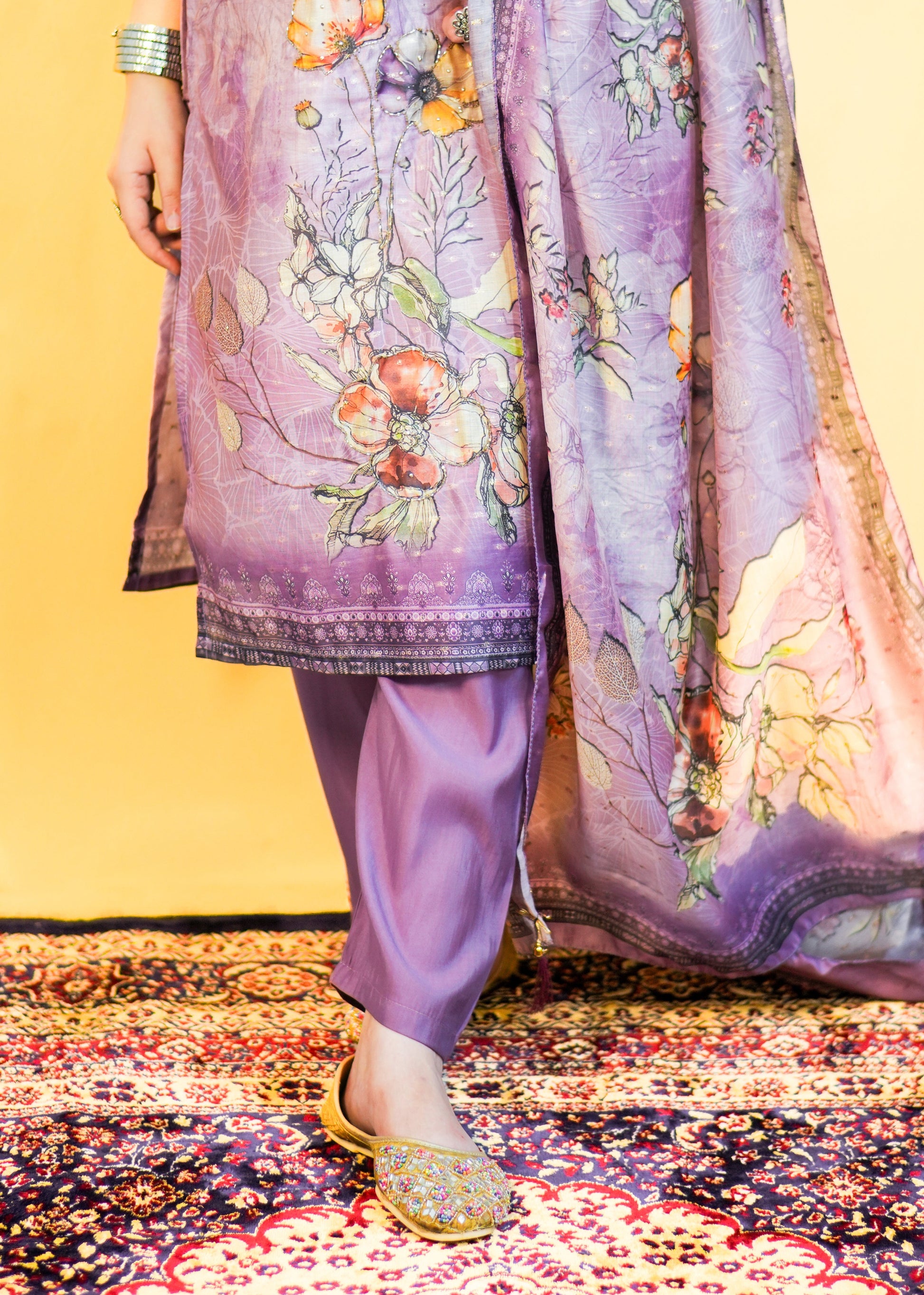 Traditional outfit with floral patterns on a colorful rug