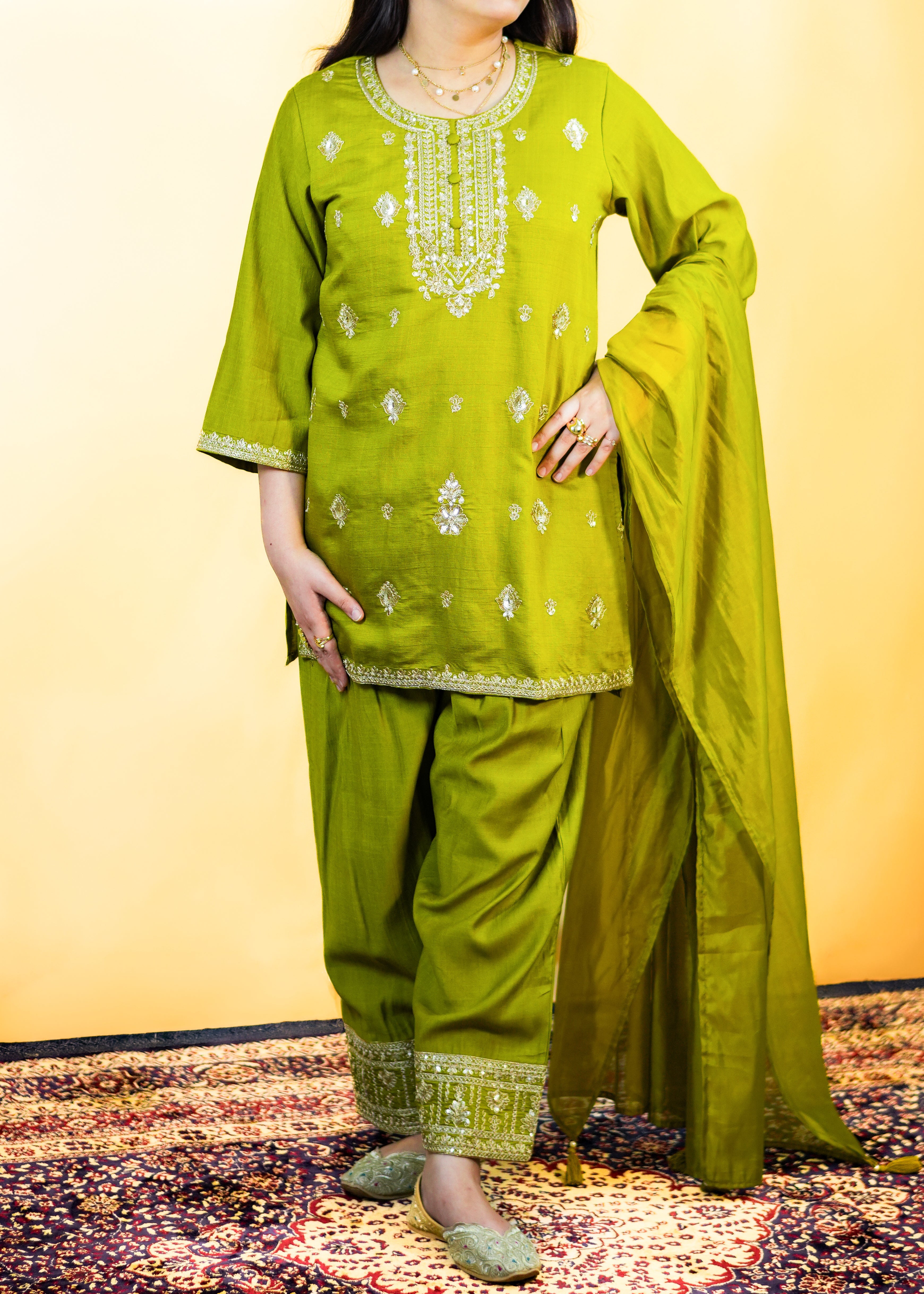 Woman wearing a green traditional outfit with a yellow background