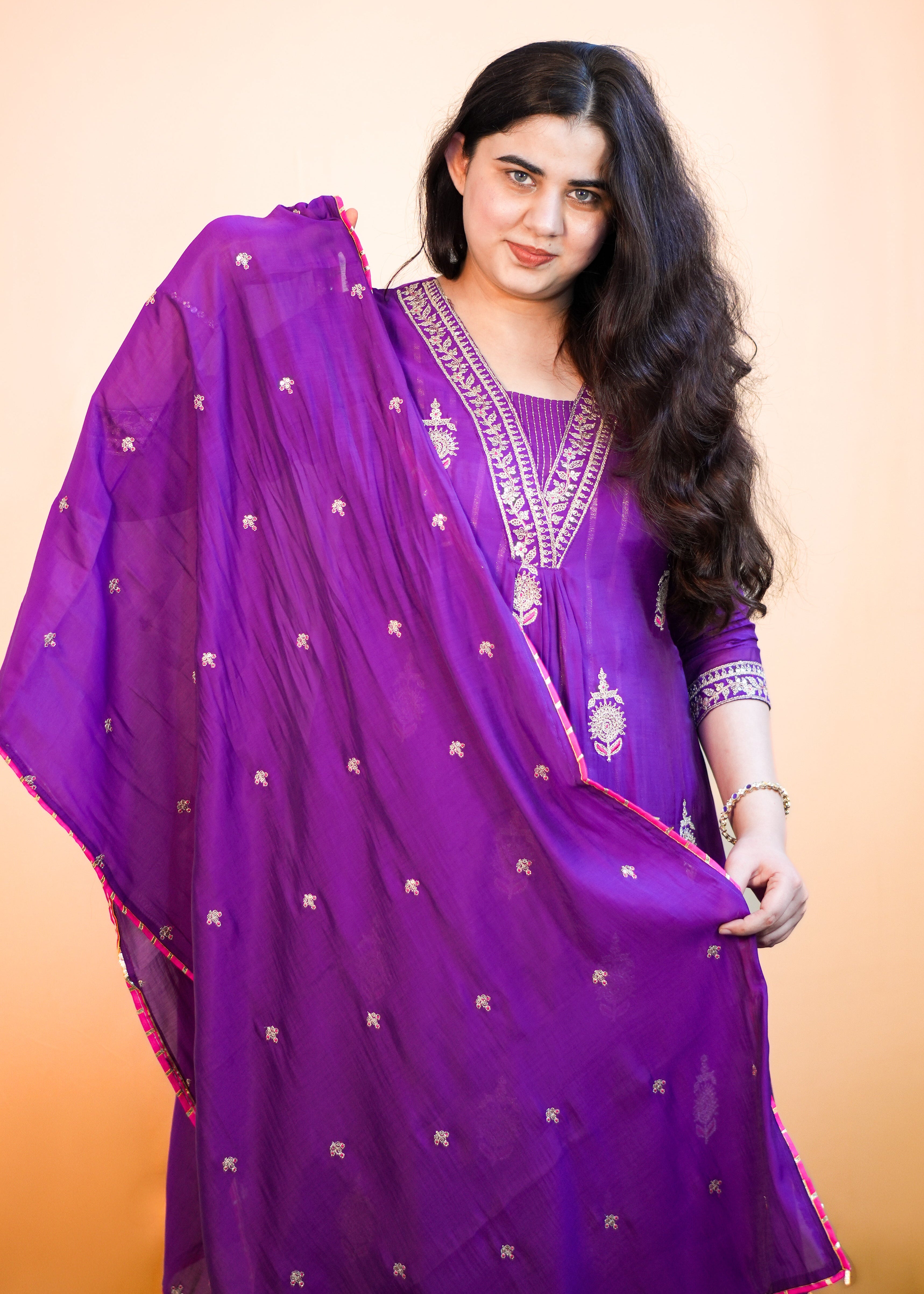 Woman wearing a purple traditional outfit with a plain background
