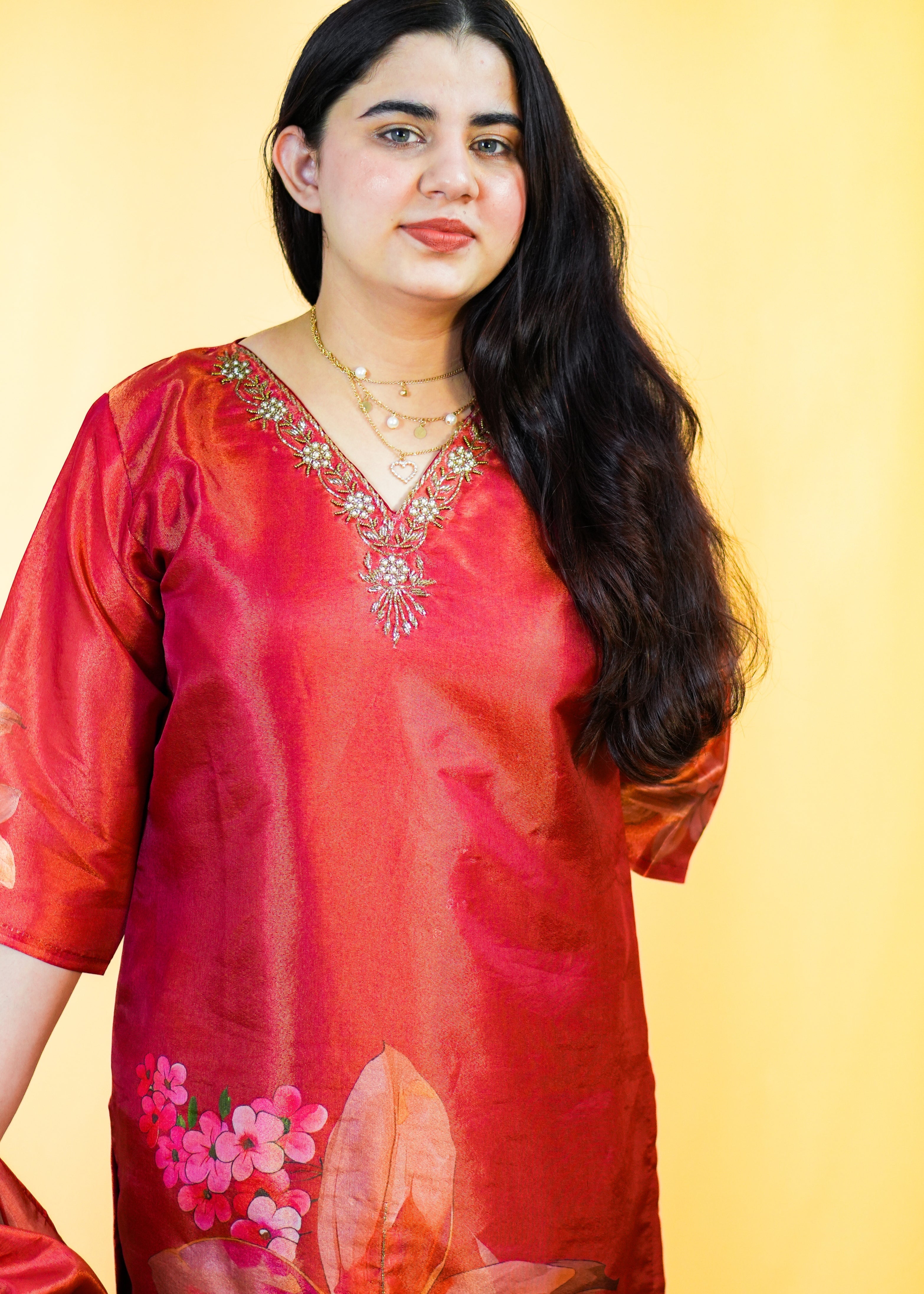 Woman wearing a red floral dress against a yellow background