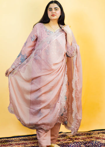 Woman in a pink traditional outfit standing on a patterned rug with a yellow background