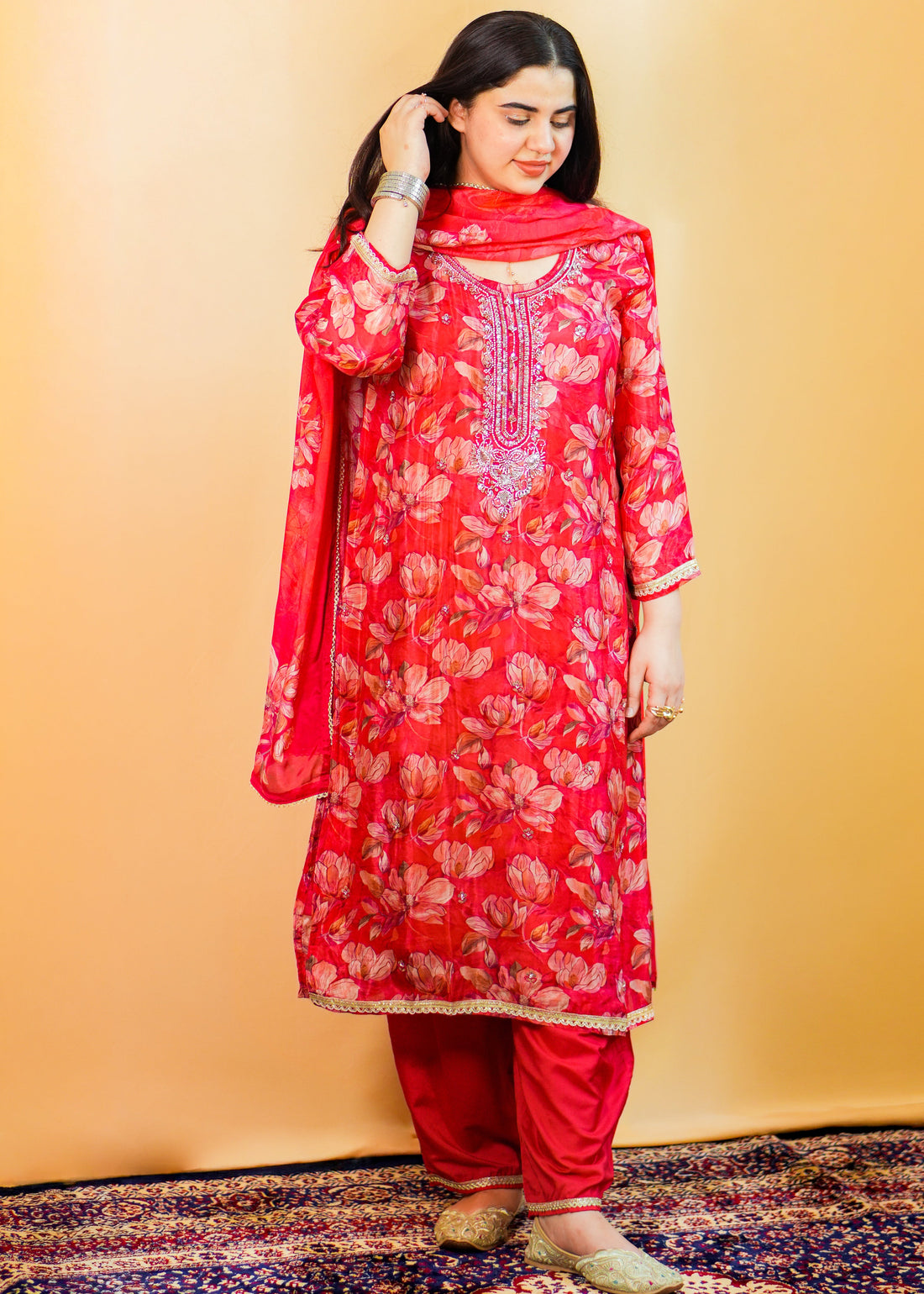 Woman wearing a red floral traditional outfit on a yellow background
