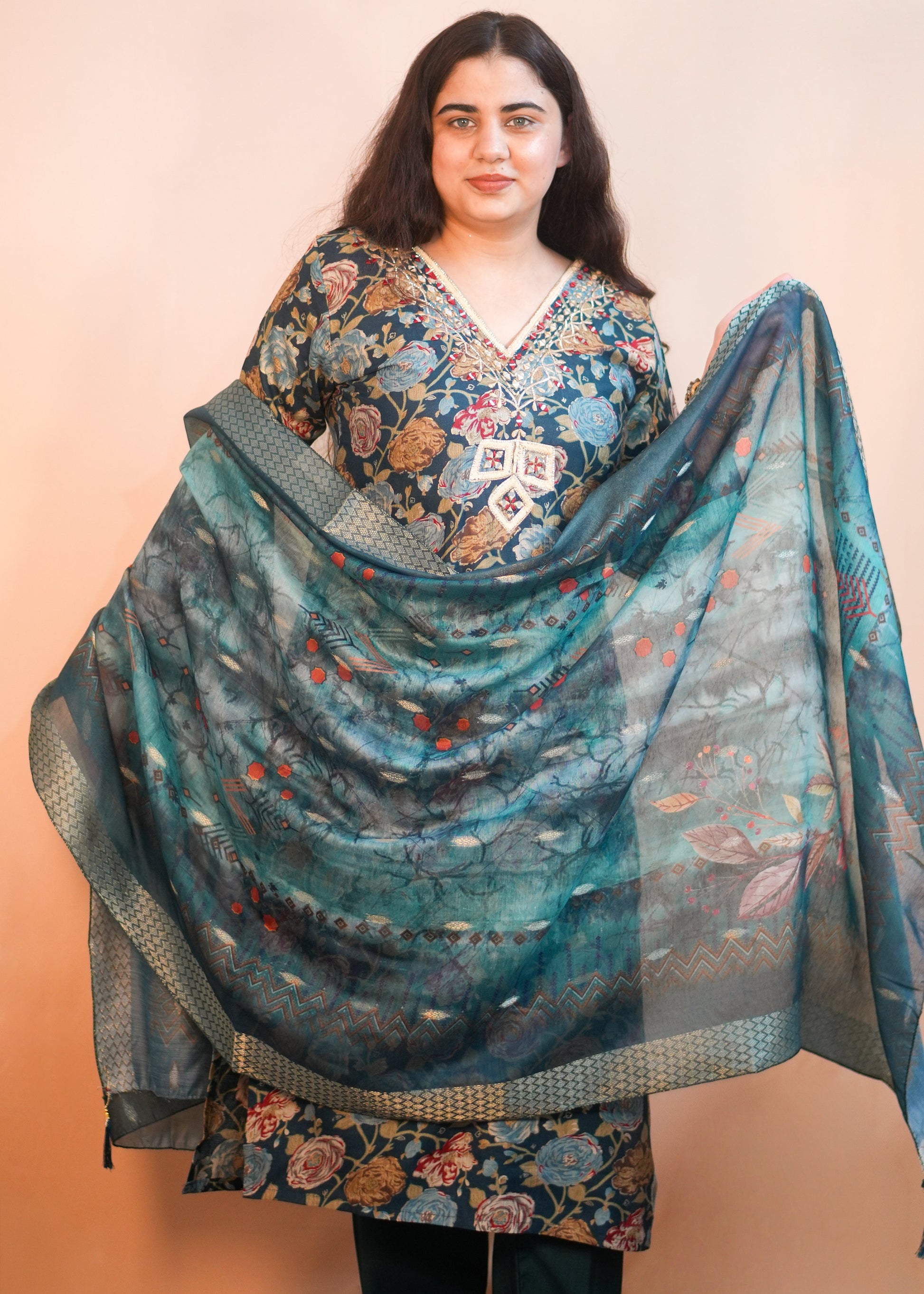 Woman wearing a floral dress with a matching shawl on a beige background