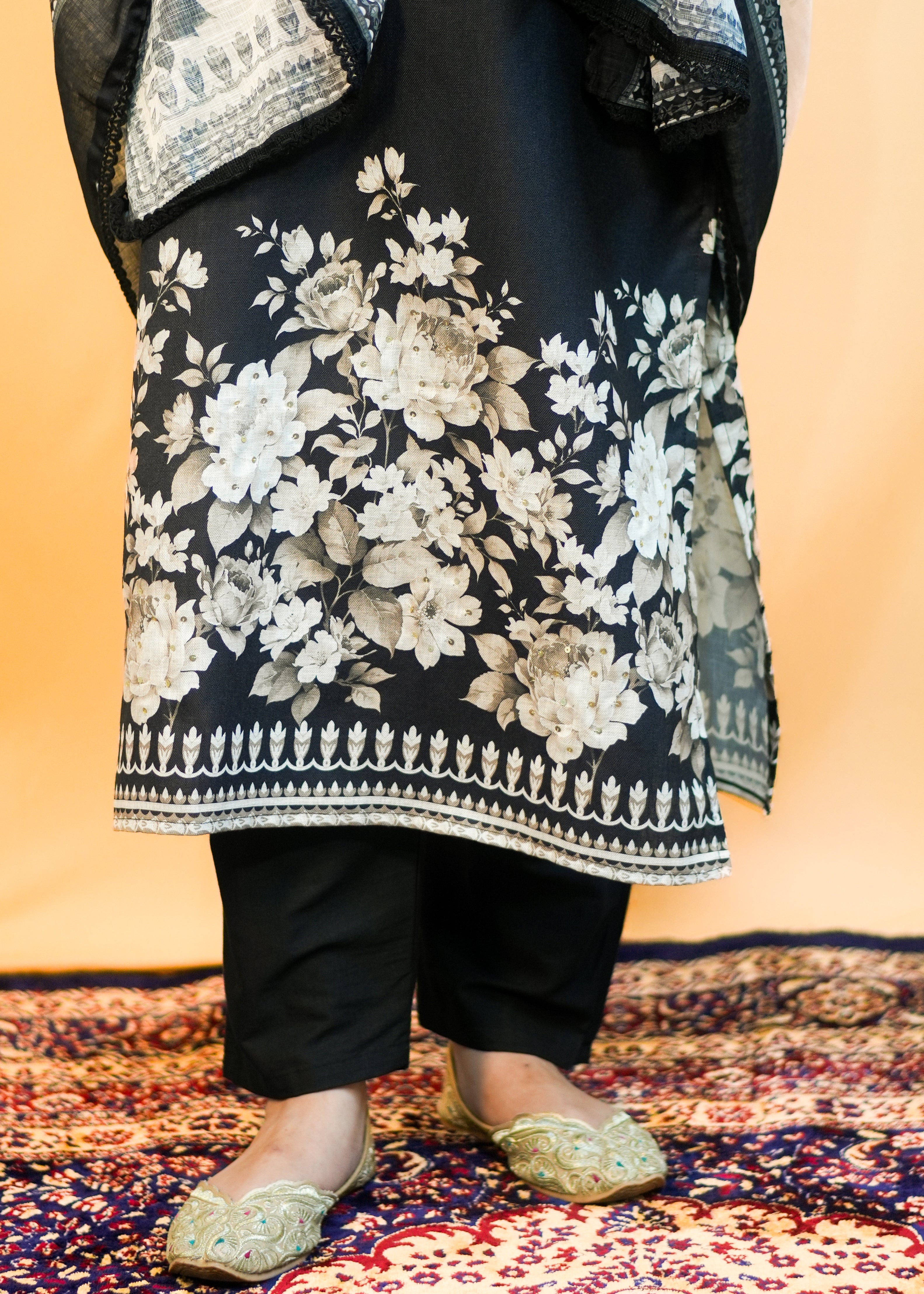 Person wearing a floral-patterned outfit with a dark background