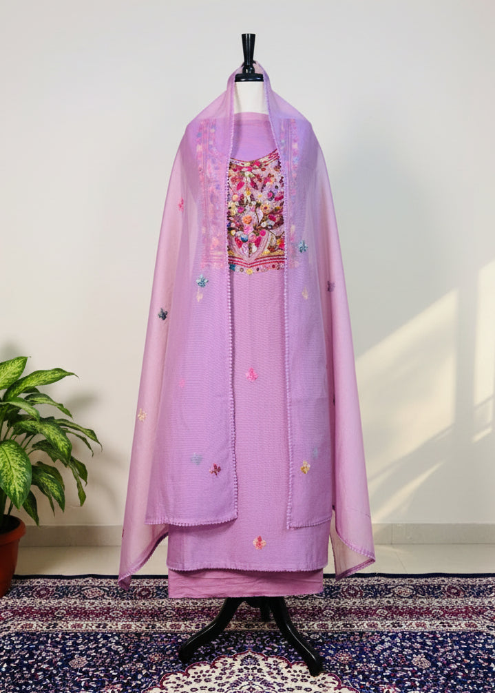 Lavender traditional outfit with floral embroidery on a mannequin against a white wall.