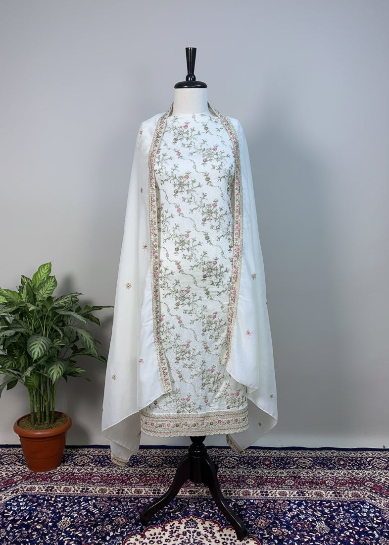White embroidered traditional outfit on a mannequin against a light gray background