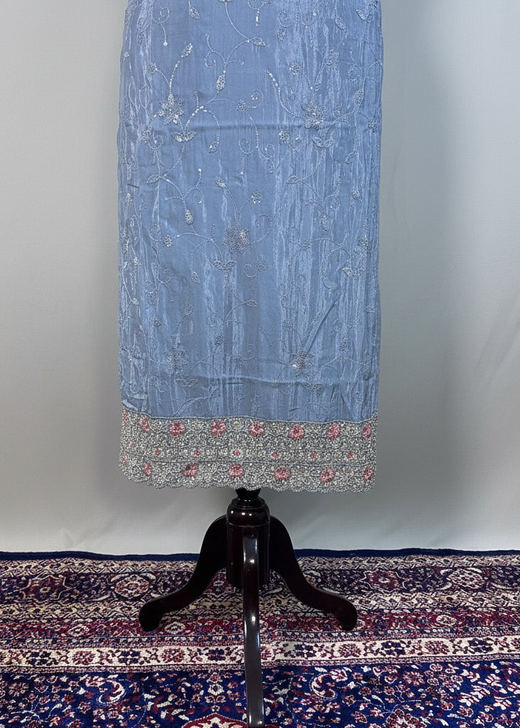 Blue floral-patterned dress on a mannequin against a beige curtain background