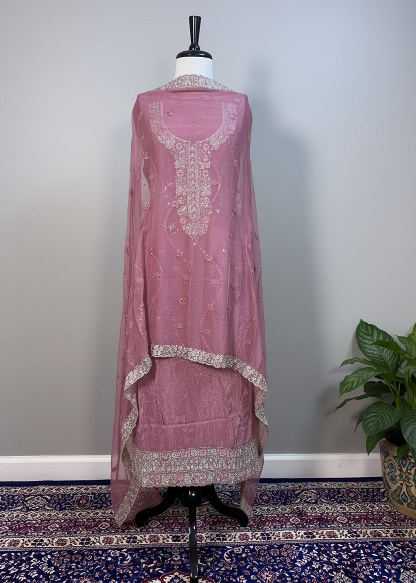 Mauve embroidered dress on a mannequin against a white curtain background