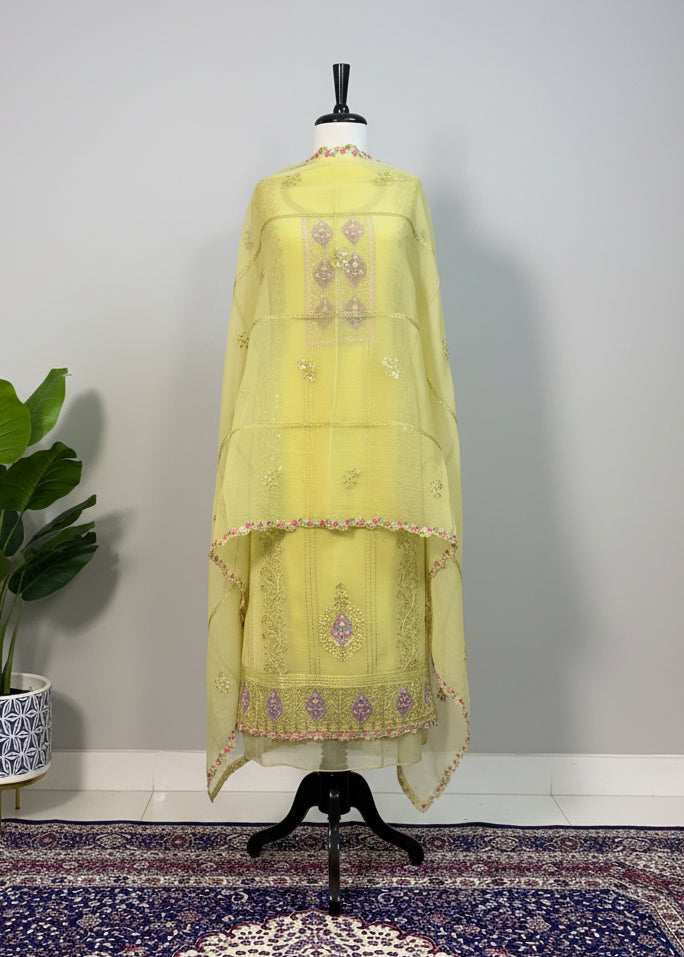 Light green embroidered dress on a mannequin against a plain background