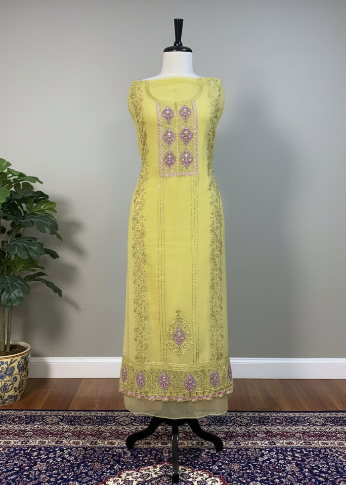 Yellow embroidered dress on a mannequin against a plain background