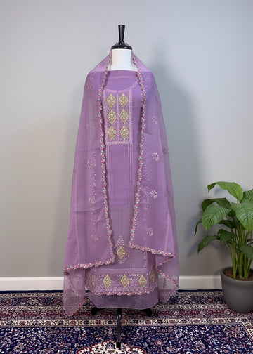 Lavender embroidered traditional outfit on a mannequin against a plain wall.