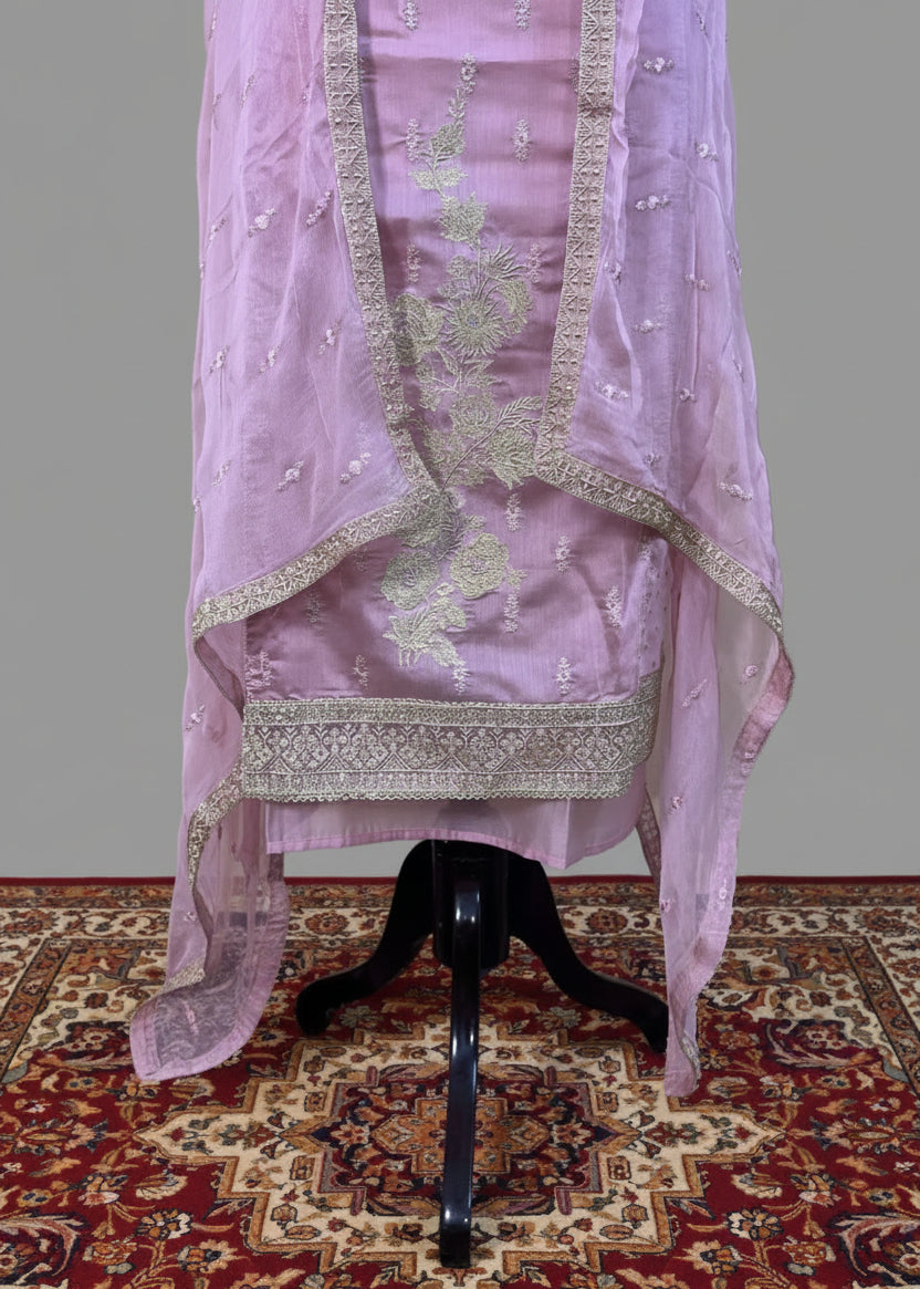 Light purple embroidered fabric on a mannequin against a plain background