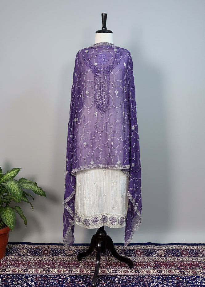 Purple embroidered top on a mannequin against a beige curtain background
