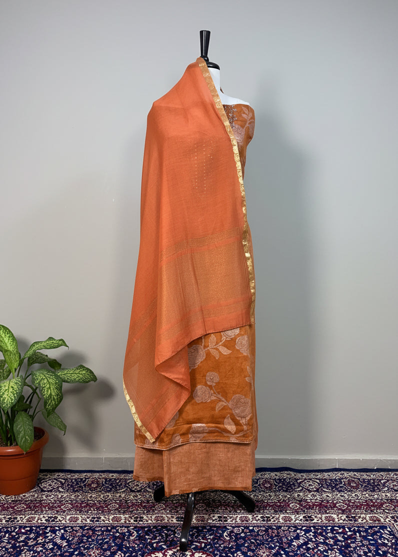 Brown saree draped over a mannequin against a white curtain background
