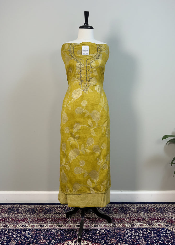 Yellow dress on a mannequin against a plain background