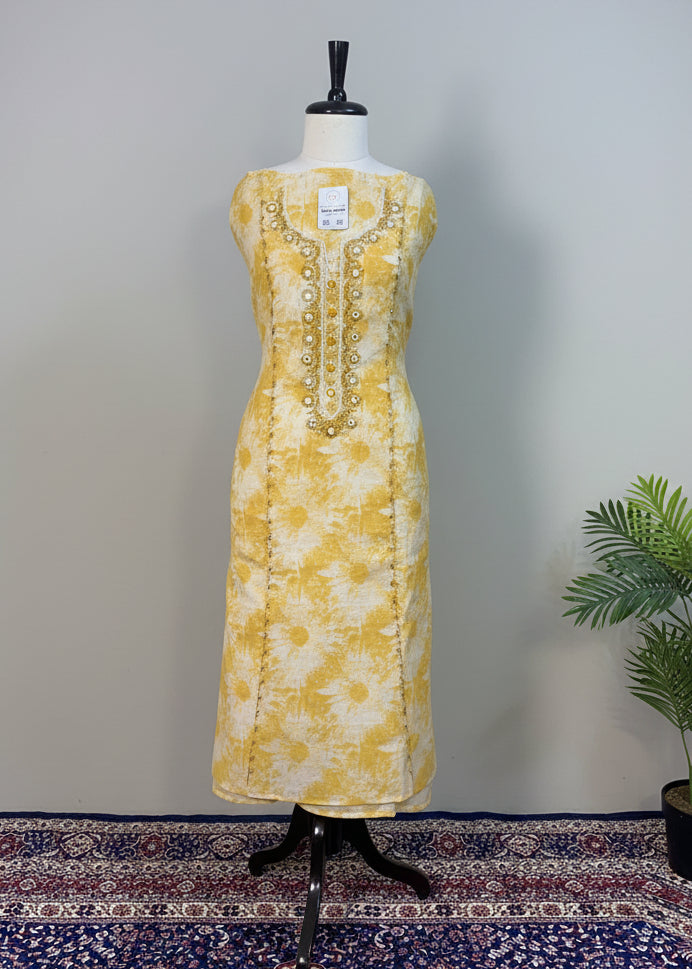 Yellow floral dress on a mannequin against a plain background