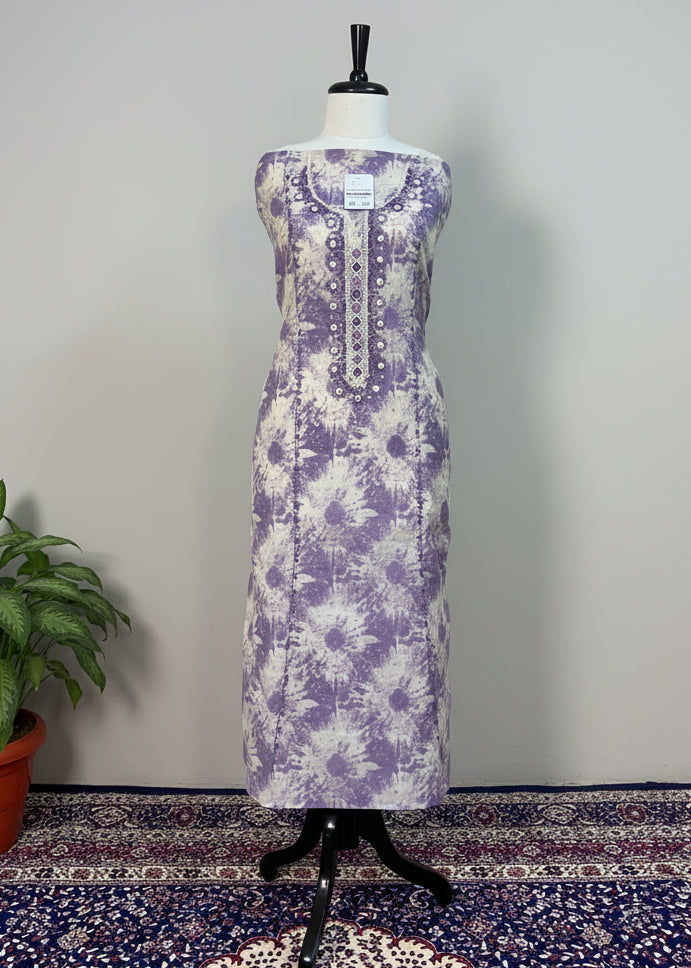 Purple floral dress on a mannequin against a beige curtain