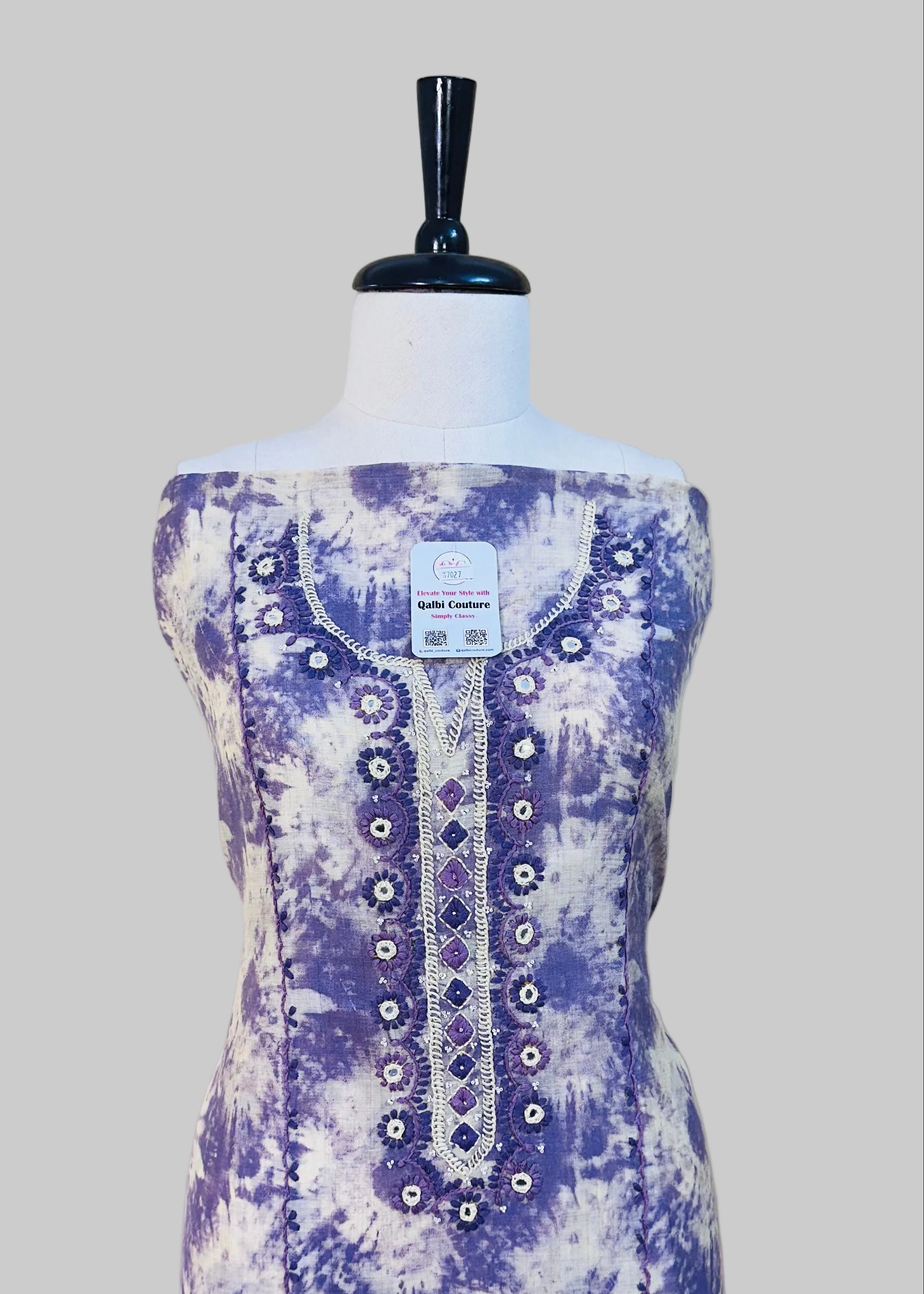 Purple and white patterned dress on a mannequin against a plain background
