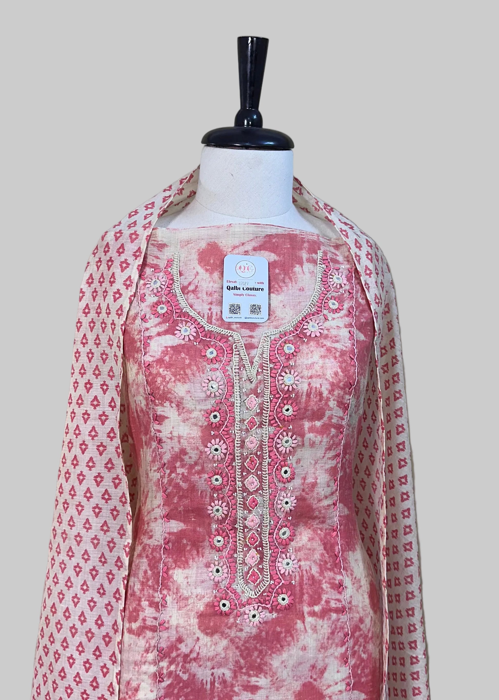 Pink and white embroidered kurta with matching dupatta on a mannequin against a beige background