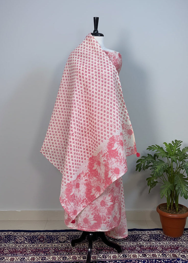 Mannequin wearing a pink and white patterned shawl against a beige curtain.