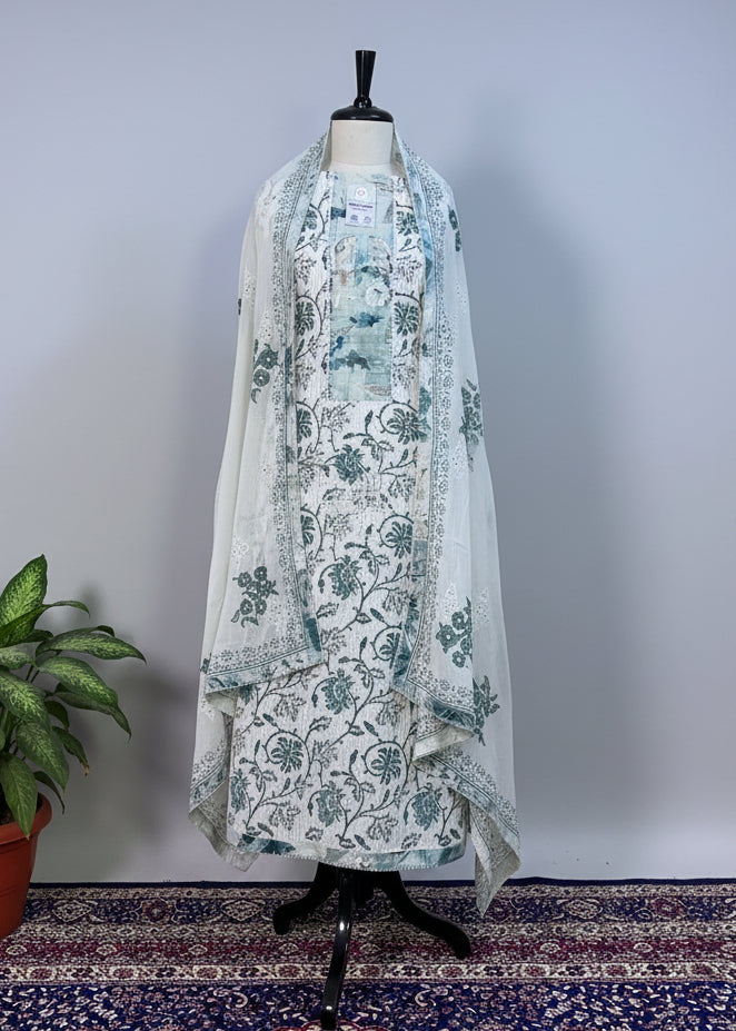 Mannequin wearing a floral dress with a long coat against a beige curtain background