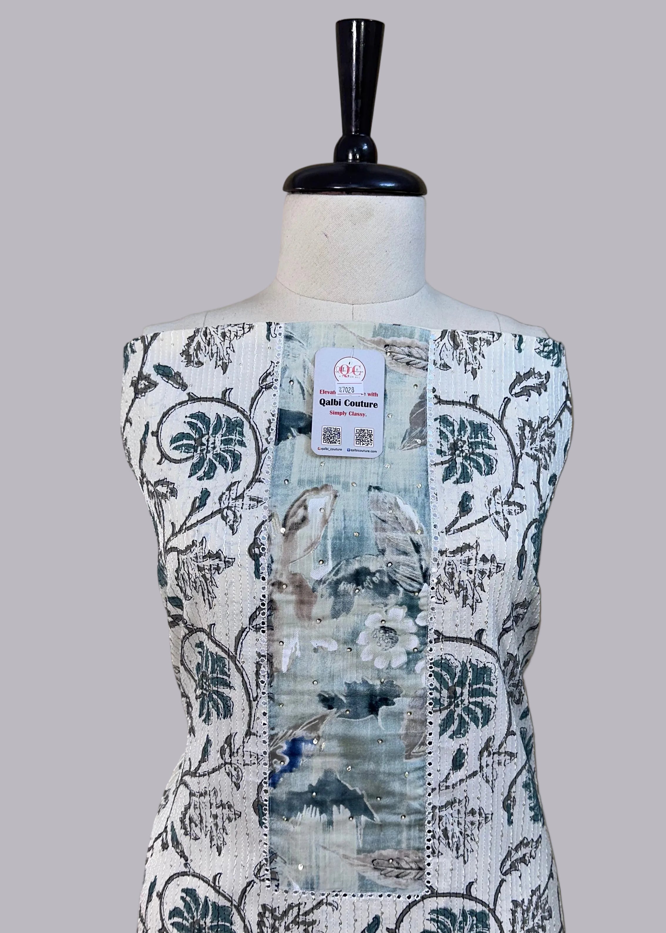 Mannequin wearing a floral patterned dress with a beige background