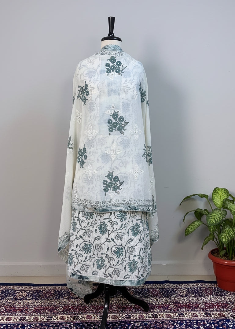 White embroidered outfit on a mannequin against a beige curtain background