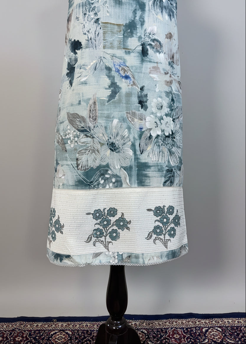 Floral dress on a mannequin against a beige curtain background