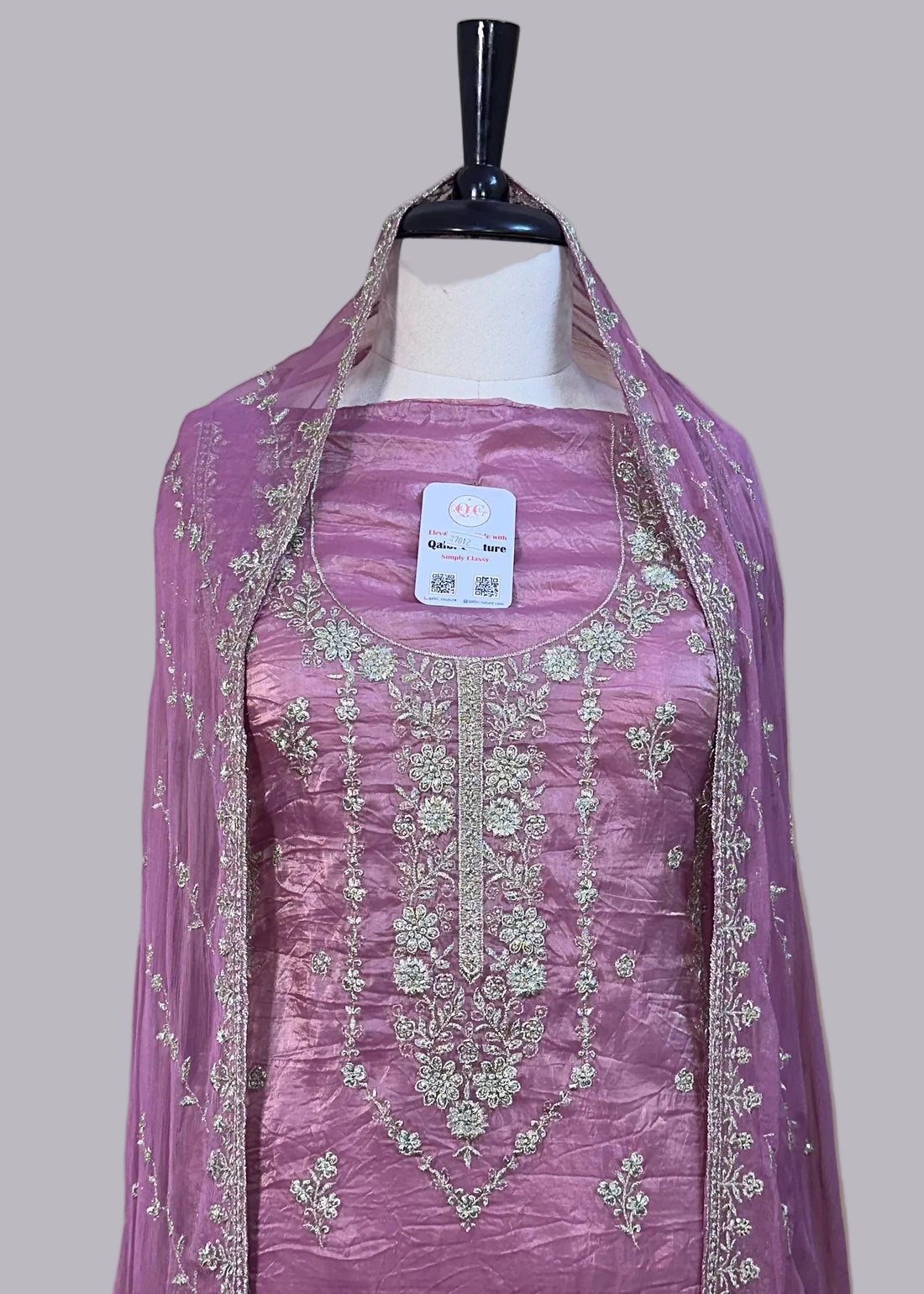 Purple embroidered dress on a mannequin with a beige background