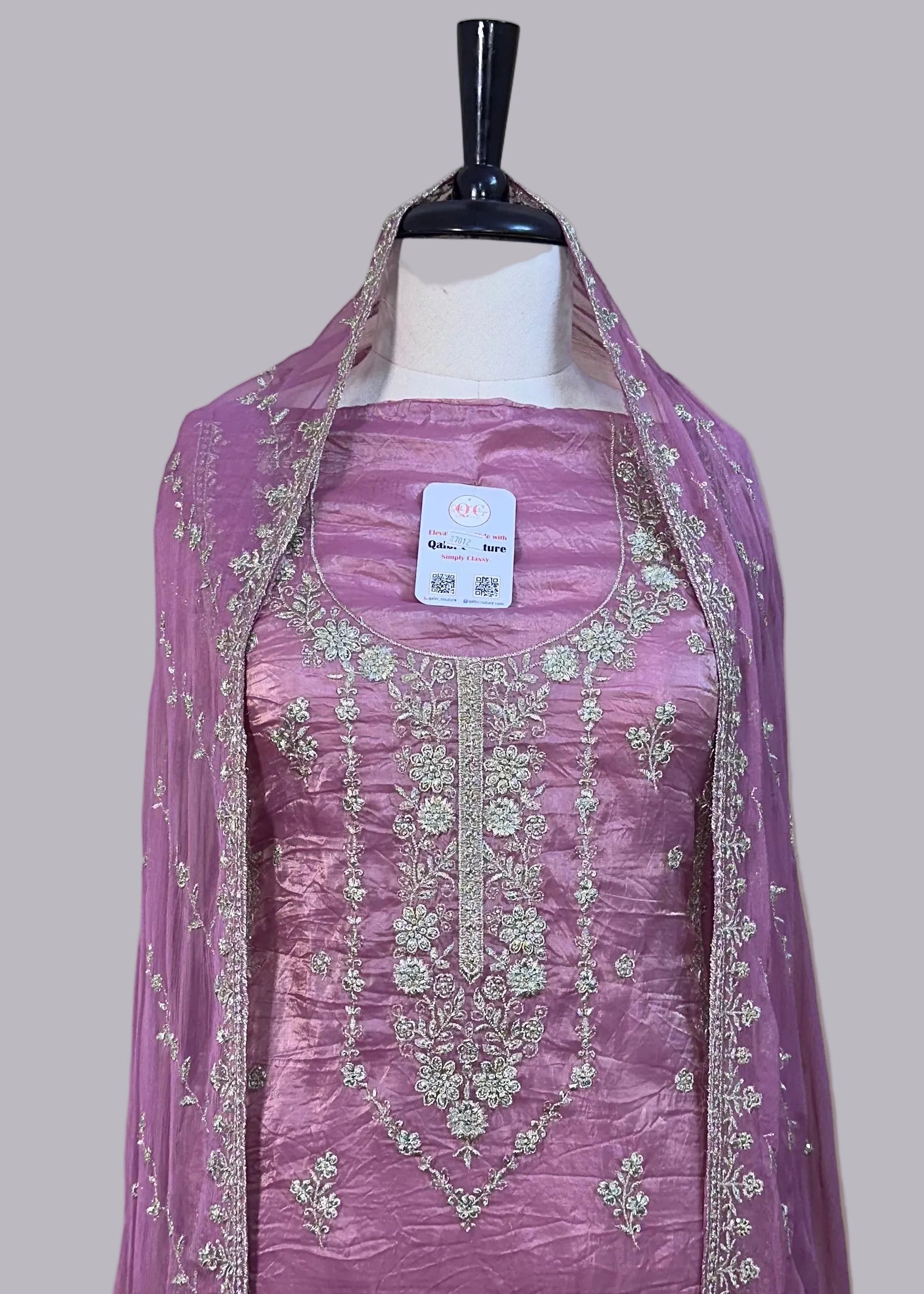 Purple embroidered dress on a mannequin with a beige background