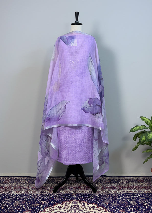 Mannequin wearing a purple dress with floral patterns on a patterned rug.
