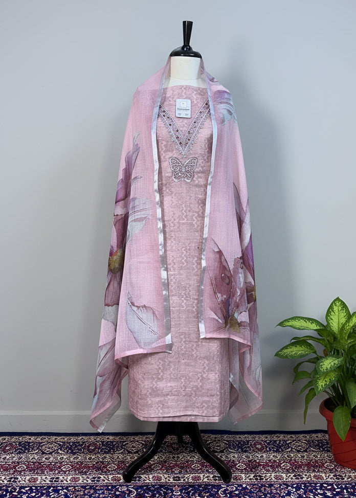 Mannequin wearing a pink dress with a matching shawl on a beige curtain background