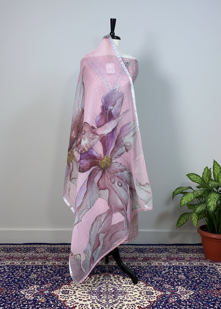 Mannequin wearing a floral pink and purple shawl against a beige curtain.