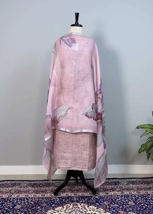Mannequin wearing a pink floral dress with a beige curtain and patterned rug in the background