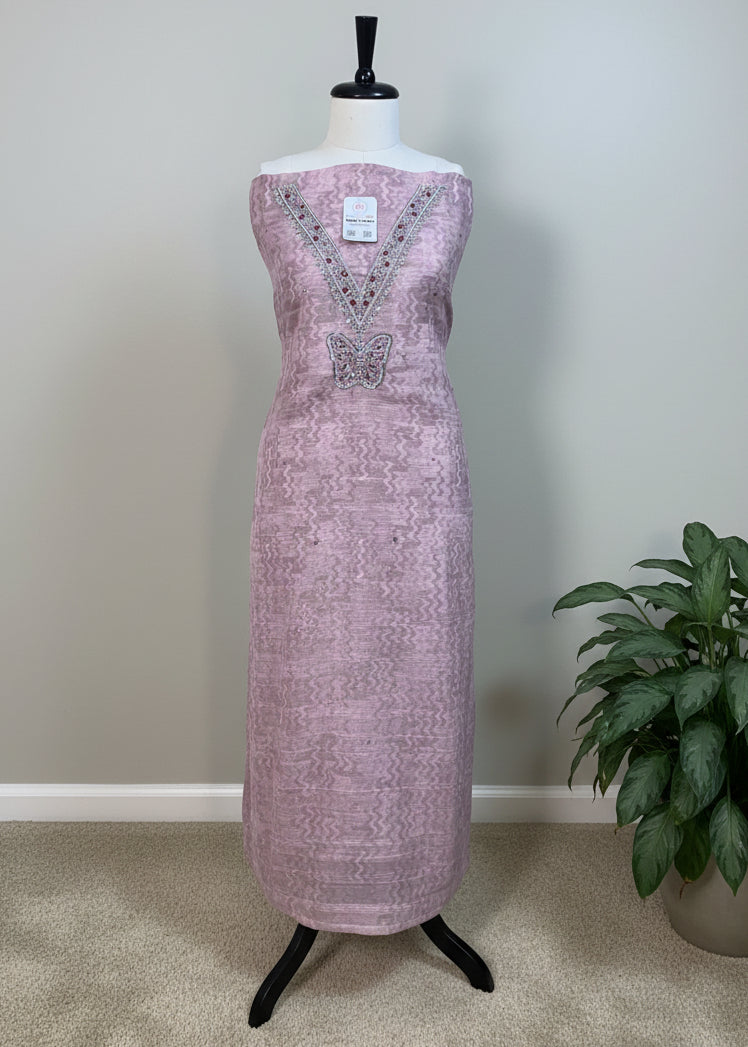 Pink dress with butterfly design on a mannequin against a beige background