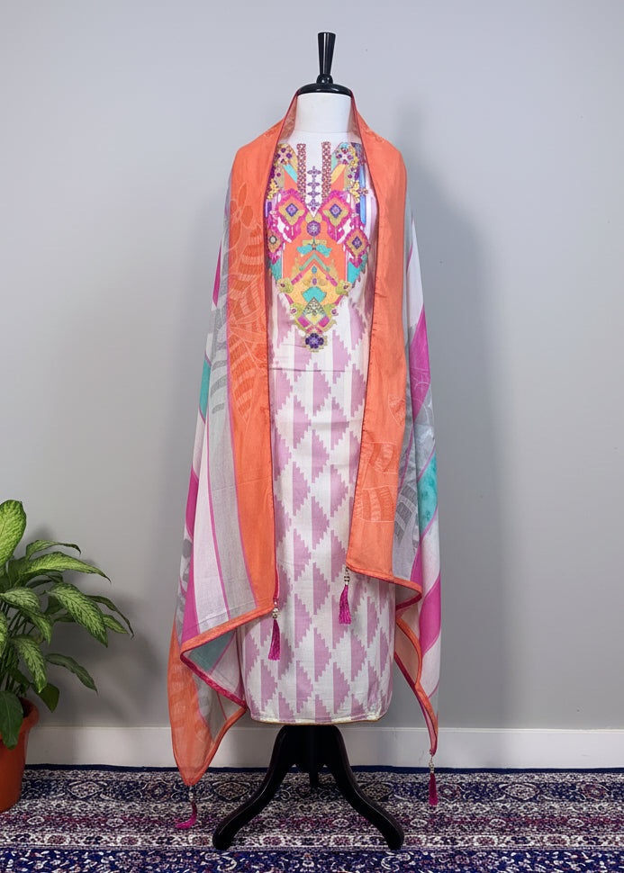 Mannequin wearing a colorful dress with an orange dupatta on a patterned rug.