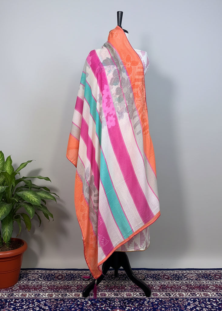 Colorful striped fabric draped over a mannequin against a beige curtain.